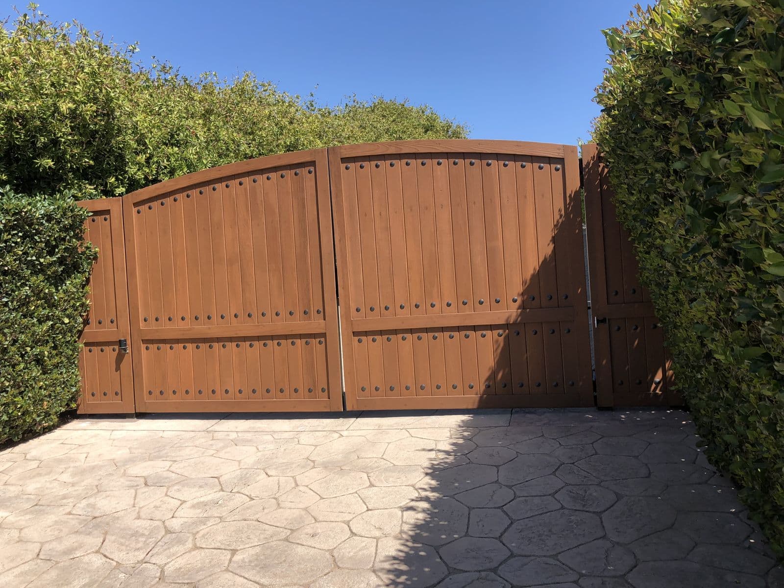 Arched wood and metal double driveway gates in Santa Clarita