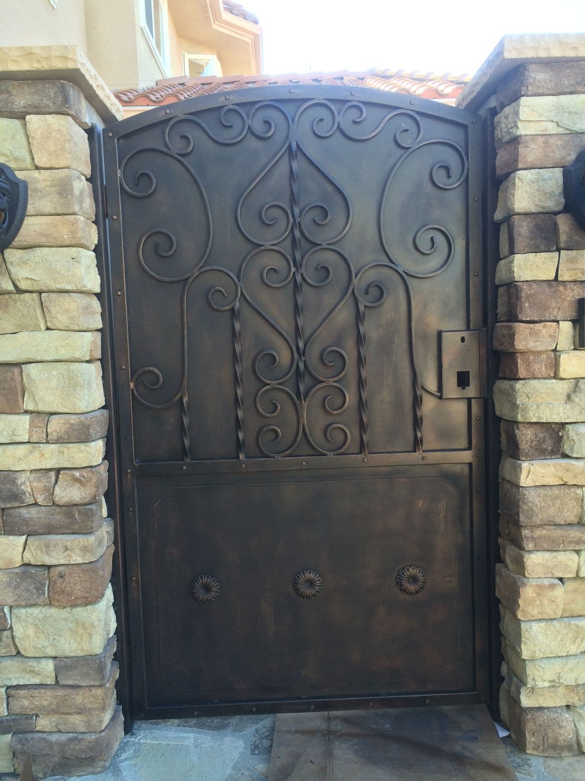 Bronze finish steel security door in a stone entryway in the Los Angeles area