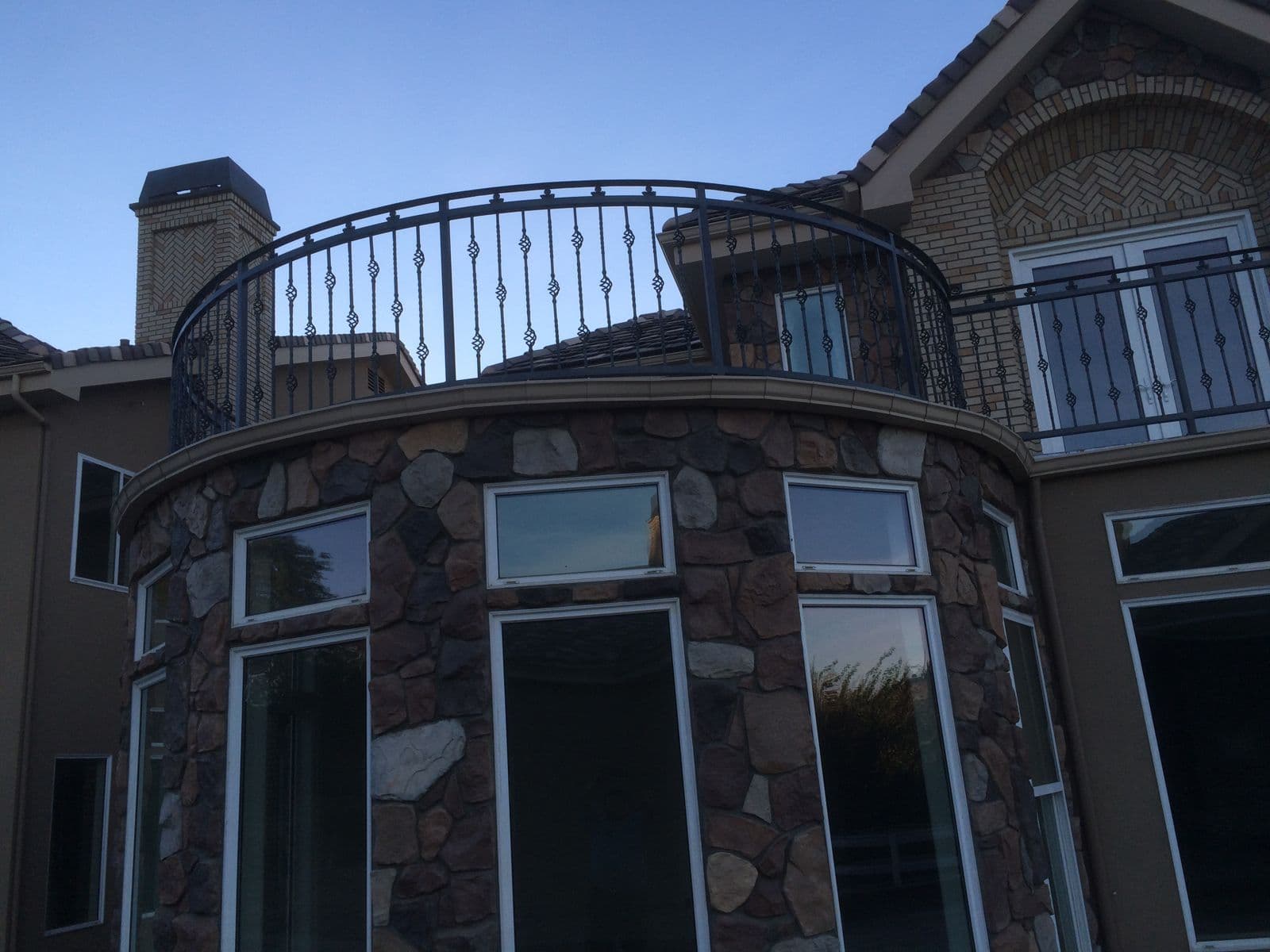 Curved iron balcony railing on stone turret
