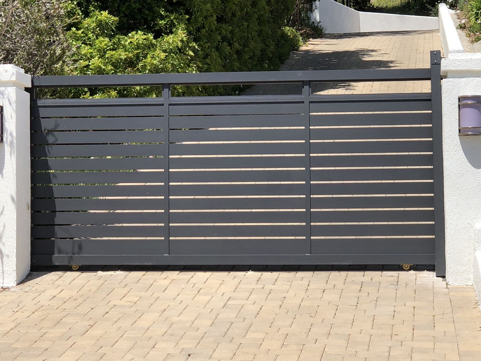 Gray horizontal slat metal driveway gate
