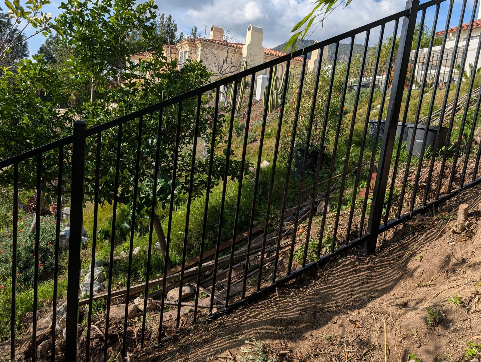 Iron fence welded and installed on a steep hillside slope