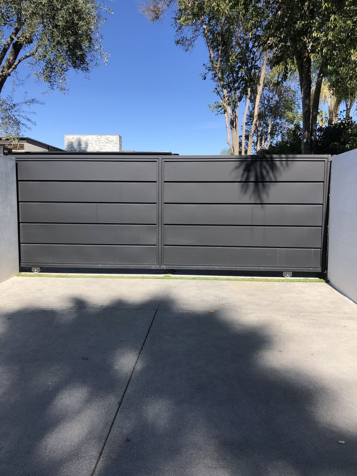 Modern gray flat-panel driveway gate