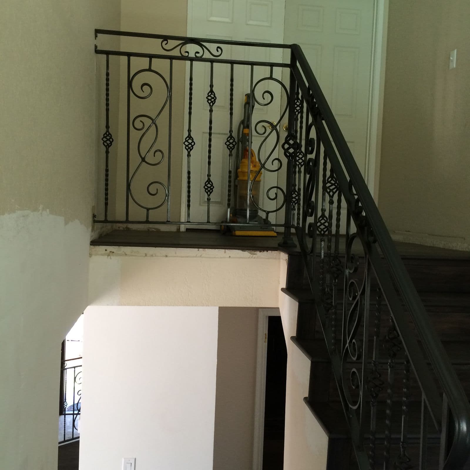 Ornate interior iron stair railing with scroll balusters