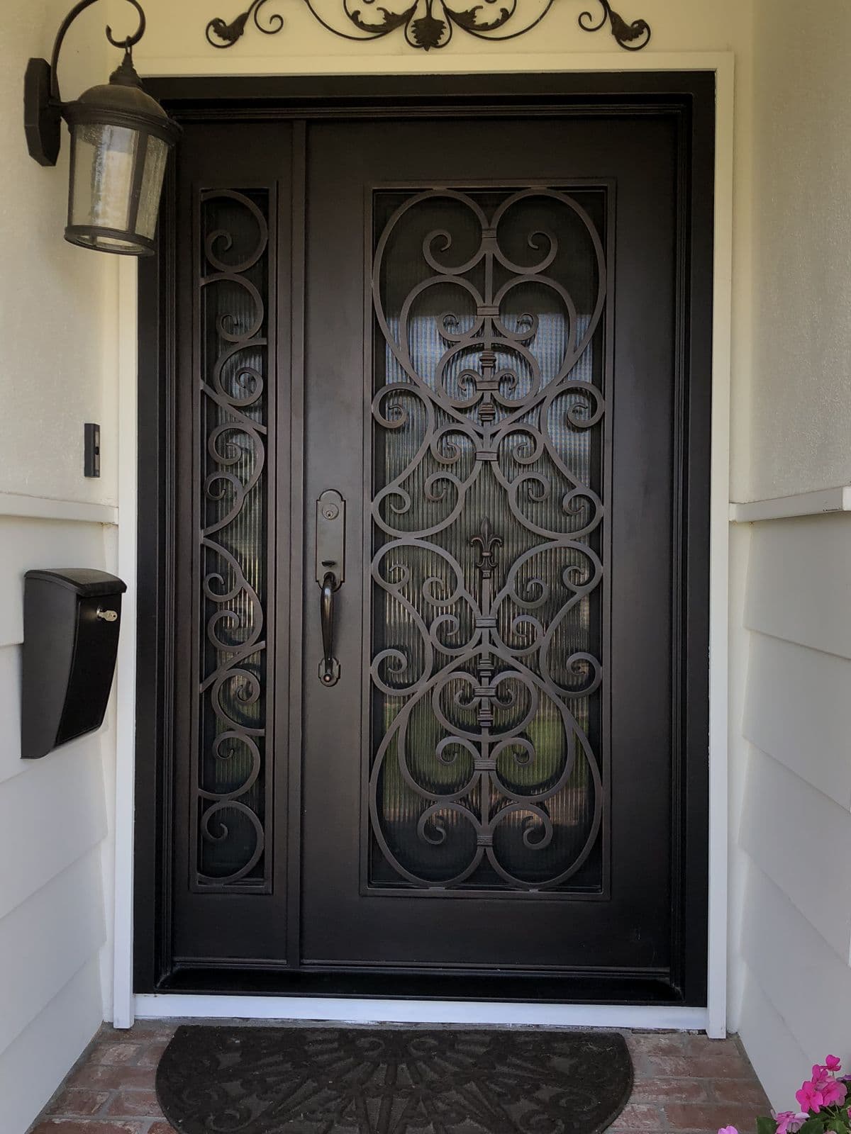 Ornate iron front entry door with scrollwork glass panel