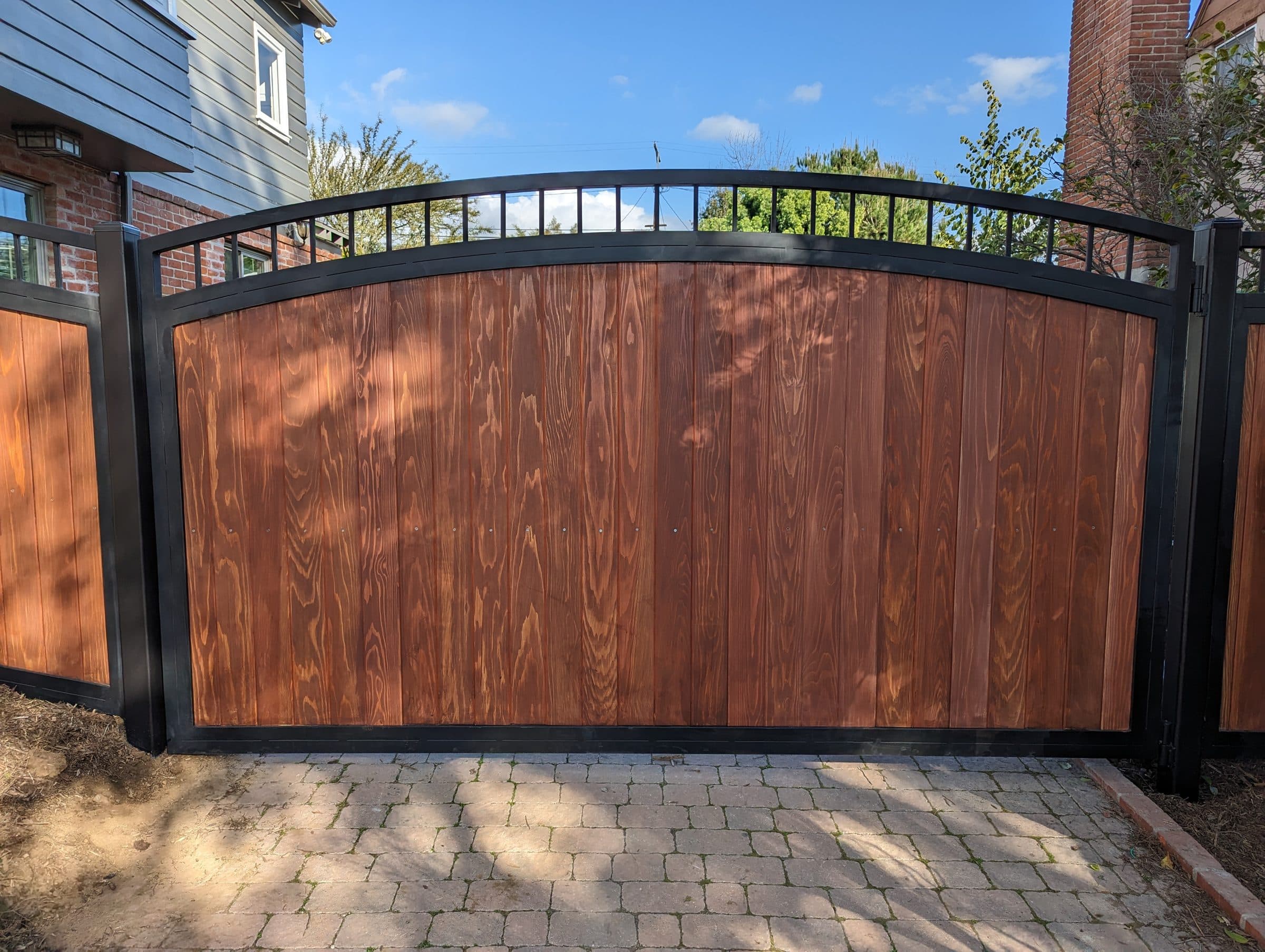 Arched redwood and steel driveway gate custom built in the Los Angeles area