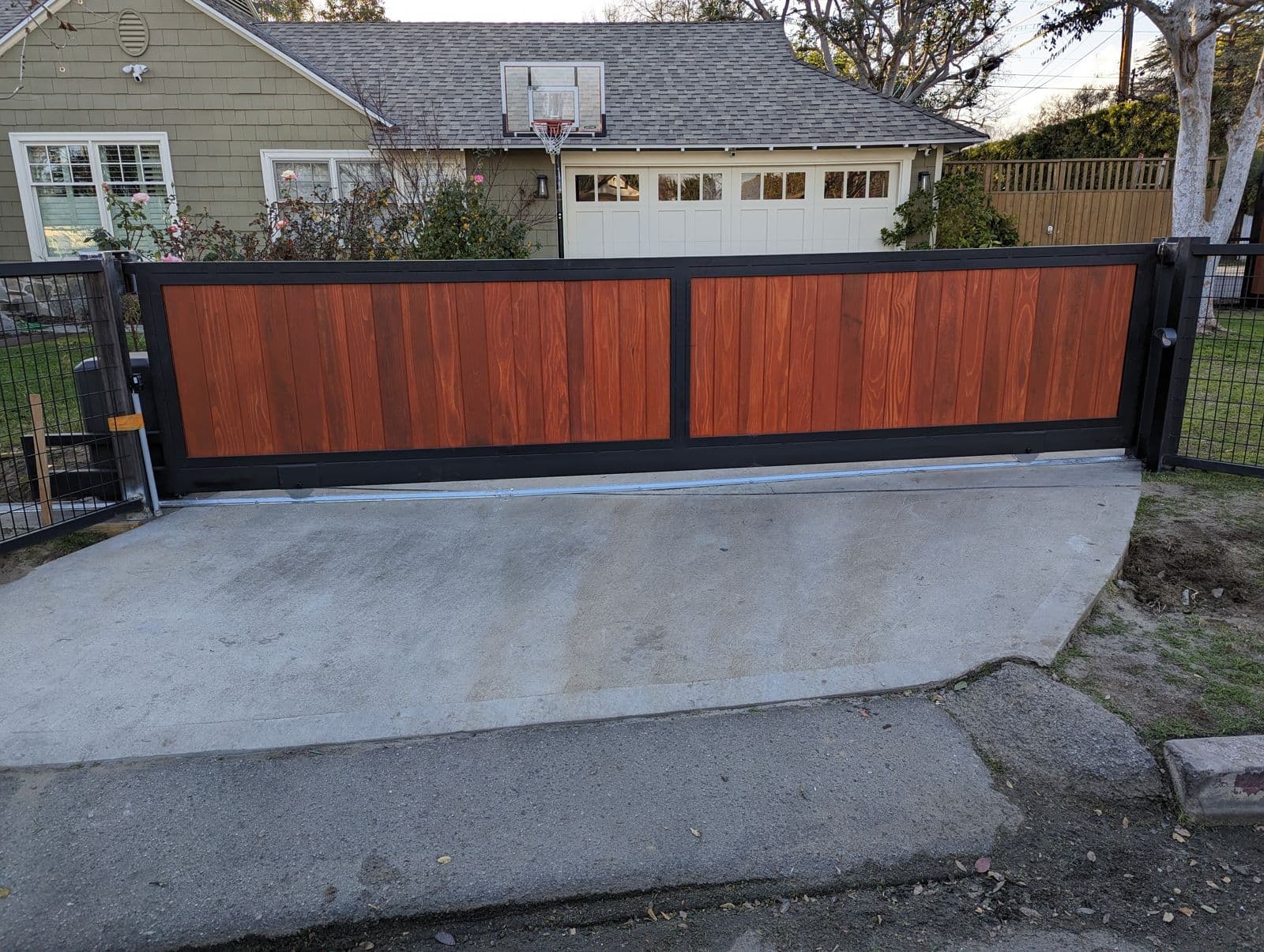 Automatic wood and steel sliding driveway gate installed in Orange County
